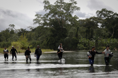 Migrantes que cruzan el río Tuquesa luego de atravesar la selva del Darién, frontera natural entre Colombia y Panamá.