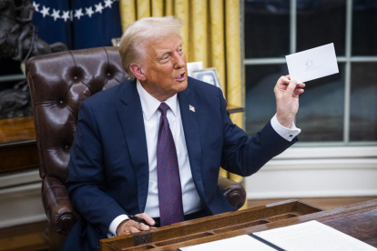 El presidente Donald Trump sostiene una carta que le dejó el exmandatario Joe Biden, este lunes 20 de enero del 2025.
