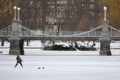 Un niño juega hockey en la laguna helada del Boston Public Garden en Boston, Massachusetts, EE.UU., el 21 de enero de 2025.