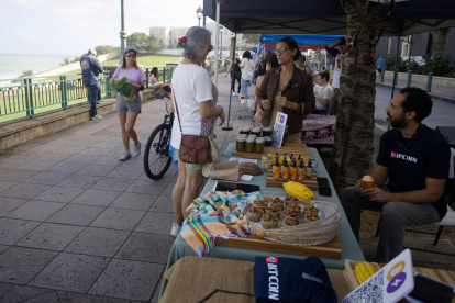 Melissa Scarcliff (c) habla con una clienta junto a José Crespo, en el Mercado Agrícola del Viejo San Juan (Puerto Rico).