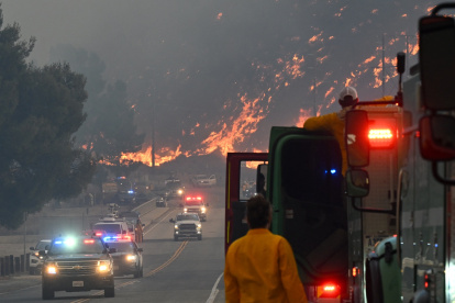 Los bomberos observan cómo las llamas del incendio Hughes queman la ladera de Castaic, un vecindario en el noroeste del condado de Los Ángeles, California, el 22 de enero de 2025.