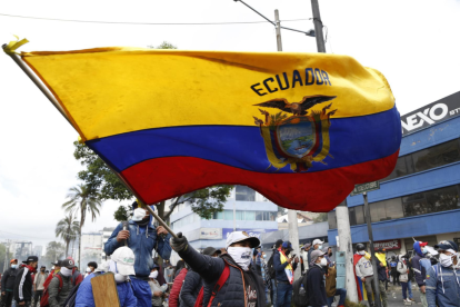 Fotografía de archivo en donde se ve a una persona que levanta una bandera de Ecuador.