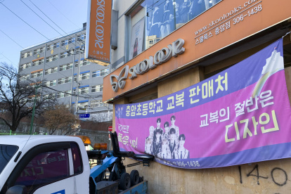 Una tienda junto al colegio Choongam anuncia la venta de uniformes escolares, cuya obligatoriedad ha rescindido la dirección de la escuela ante el acoso y los ataques que han sufrido sus alumnos.