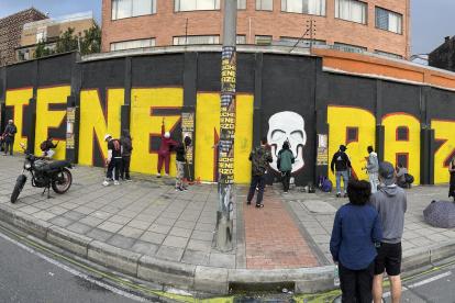 Foto panorámica de integrantes de colectivos artísticos pintando un grafiti este viernes en Bogotá (Colombia).