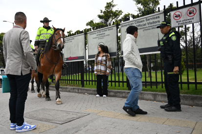 Agentes de la policía montada patrullan frente a la embajada de Estados Unidos, donde la gente espera después de que se cancelaran sus citas para visas en Bogotá el 27 de enero de 2025.
