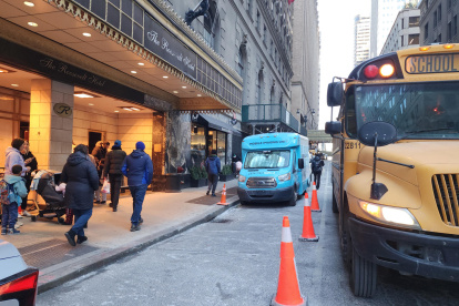 Padres esperan con sus niños al autobús escolar este lunes en Nueva York (EE.UU.).