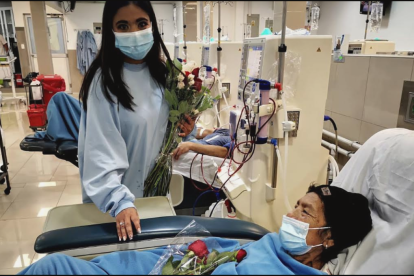 Alejandra Valdez (de pie), luego de someterse a diálisis, entrega flores a una compañera, en una clínica privada.