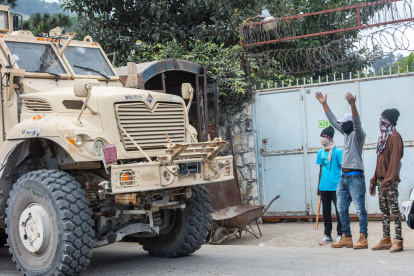 Integrantes de una brigada de protección barrial dan acceso a un camión blindado del ejército haitiano este miércoles, en Kenscoff (Haití).