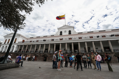 Fotografía de archivo de Ciudadanos ecuatorianos caminando a las afueras del Palacio de Gobierno en Quito (Ecuador).