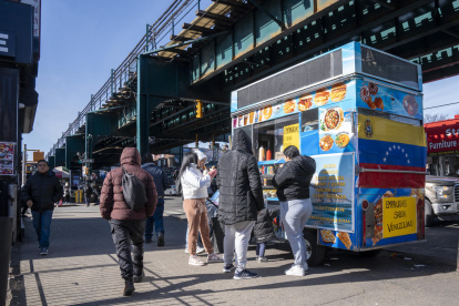 Personas consumen alimentos en un puesto de comida callejera este miércoles, en Queens Nueva York (Estados Unidos).