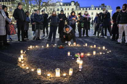 Ciudadanos se reúnen alrededor de flores y velas para honrar a las víctimas del tiroteo en la escuela de Orebro, en Malmo, Suecia.