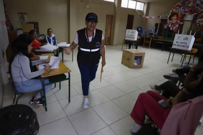 Una funcionaria del Consejo Nacional Electoral (CNE) sale de puesto de votación este domingo, en Olón (Ecuador).