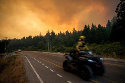 Un bombero conduce una motocicleta hacia un incendio forestal en las montañas de Mallín Ahogado, cerca de El Bolsón, en la provincia patagónica de Río Negro, Argentina, el 9 de febrero de 2025.)