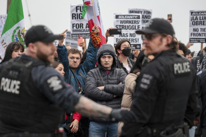 Manifestantes observan a los agentes de la policía después de que los agentes realizaron uno de los dos arrestos durante una marcha contra el ICE en Seattle, el 8 de febrero de 2025.