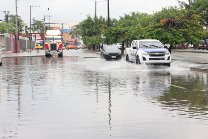 Los vehículos sufren dificultades al transitar por calles anegadas.