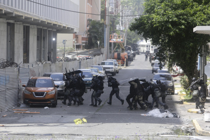 Policías antidisturbios enfrentan a integrantes de grupos sindicales durante protestas este miércoles en la cinta costera en Ciudad de Panamá (Panamá).