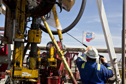 A Nabors Industries Ltd. roughneck uses a power washer to clean the drilling floor of a rig drilling for Chevron Corp. in the Permian Basin near Midland, Texas, U.S., on Thursday, March 1, 2018. Chevron, the world"s third-largest publicly traded oil producer, is spending $3.3 billion this year in the Permian and an additional $1 billion in other shale basins. Its expansion will further bolster U.S. oil output, which already exceeds 10 million barrels a day, surpassing the record set in 1970. Photographer: Daniel Acker/Bloomberg via Getty Images