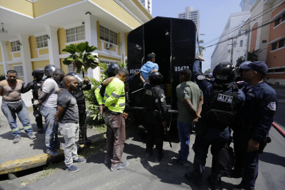 Policías antidisturbios custodian a integrantes de grupos sindicales durante protestas este miércoles en Ciudad de Panamá (Panamá).