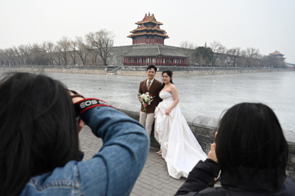 Una pareja posa para fotografías de boda en las afueras de la Ciudad Prohibida en Beijing el 11 de febrero de 2025. El año pasado, China experimentó una disminución de una quinta parte en los matrimonios.
