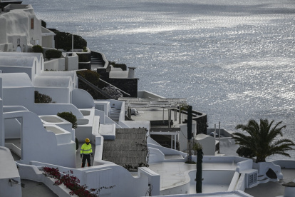 A municipal employee walks in the village of Oia on the Greek island of Santorini while the authorities restricted  access to the tourists in some areas as a precaution due to recent seismic activity on February 5, 2025. Some 7,000 people have left the island, known for its spectacular cliffside views and dormant volcano, which has been hit by hundreds of tremors since January 24, 2025, officials said. (Photo by STRINGER / AFP)
