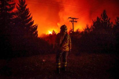 Fotografía cedida por Greenpeace de un bombero observando un incendio en Río Negro (Argentina).
