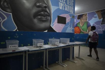 Una estudiante camina hacia su salón de clases después de dejar su teléfono celular en una caja al comienzo del día escolar en la escuela pública Reverend Martin Luther King en Río de Janeiro.