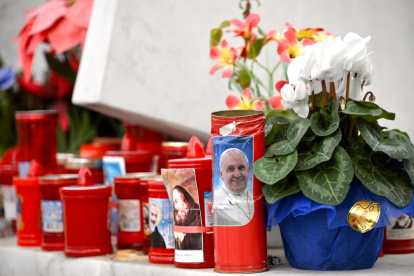 Se colocan flores y velas al pie de una estatua del papa San Juan Pablo II frente al Hospital Universitario Gemelli, en Roma, donde el Papa Francisco está hospitalizado.