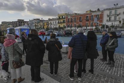 Fieles rezan el rosario frente a una estatua de la Virgen en la cancha de baloncesto del paseo marítimo de Pertini en Pozzuoli, cerca de Nápoles (Italia), el 17 de febrero de 2025.