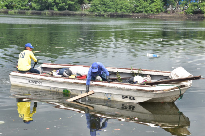 Los trabajadores municipales realizan su recorrido en balsas.