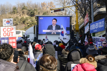 Los partidarios miran imágenes de archivo de los discursos del líder surcoreano Yoon Suk Yeol (C) en una pantalla cerca del Tribunal del Distrito Central en Seúl el 20 de febrero de 2025.