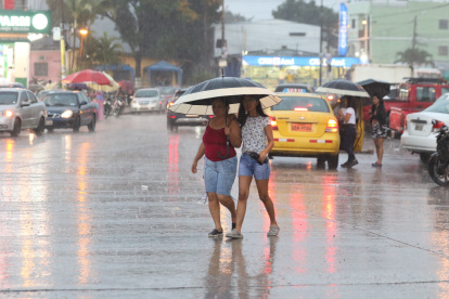 La lluvia se sintió en algunas partes de la ciudad. Se veía a personas resguardándose de las precipitaciones