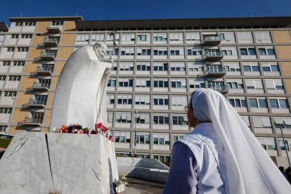 Una monja reza ante una estatua del Papa San Juan Pablo II fuera del Hospital Universitario Gemelli, donde el Papa Francisco está hospitalizado por tratamiento de bronquitis, en Roma, Italia, 21 de febrero de 2025.