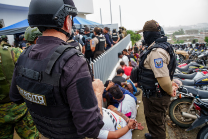 Integrantes de la Policía de Ecuador y del Ejército Ecuatoriano vigilan a un grupo de personas detenidas en un operativo este miércoles, en Guayaquil (Ecuador).