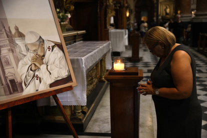 Una mujer reza junto a un cuadro que representa al Papa Francisco en la Basílica de San José de Flores en Buenos Aires, este domingo 23 de febrero de 2025.