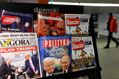 Un hombre camina por un pasaje subterráneo pasando por un quiosco que vende revistas con portadas que representan al presidente ruso Vladimir Putin y al presidente estadounidense Donald Trump en Varsovia.