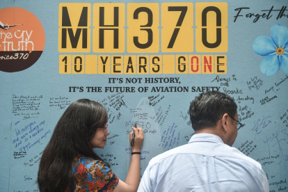 Una mujer escribe un mensaje durante un evento organizado por familiares de los pasajeros y simpatizantes para conmemorar el décimo año desde que el vuelo MH370 de Malaysia Airlines.