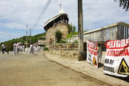 Abismo. La vía que colinda con el templo y el colegio es solo peatonal y ya no vehicular desde hace dos años. Letreros advierte del daño.