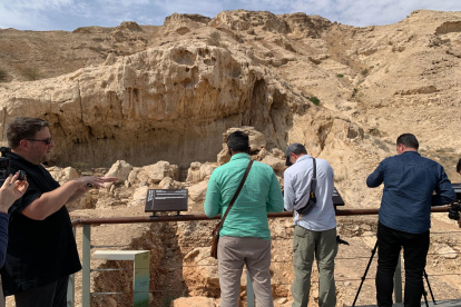 Visitantes que observan un yacimiento al pie de la cordillera de Jebel Faya, en el desierto emiratí de Sharjah.