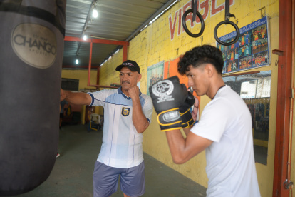 El entrenador y excampeón de boxeo Pablo Álvarez (c), comparte sus enseñanzas todas las tardes con jóvenes en el suburbio de Guayaquil.