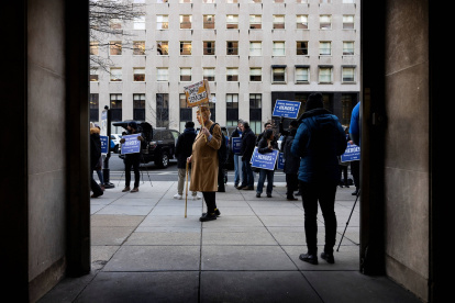 Un manifestante vestido como Donald Trump con una corona sostiene un cartel mientras otros miembros del sindicato IAM, NFFE-IAM, protestas frente a la estación de metro McPherson Square.