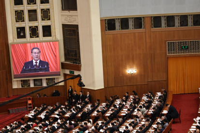 El primer ministro chino, Li Qiang, es visto en una pantalla mientras pronuncia su discurso durante la ceremonia de apertura de la Tercera Sesión del 14º Congreso Nacional, en el Gran Salón del Pueblo en Pekín.
