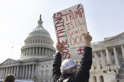 Un manifestante contra el presidente estadounidense Donald Trump y el representante de DOGE Elon Musk agita un cartel afuera del Capitolio, el 4 de marzo de 2025.