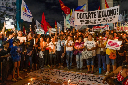 Manifestantes durante vigilia con velas para exigir justicia para las víctimas de la guerra contra las drogas, tras arresto del expresidente Rodrigo Duterte, en la ciudad de Quezón.