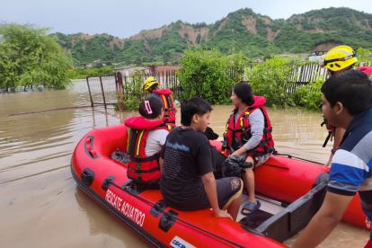 Inundaciones en San Clemente debido al temporal invernal en Manabí, con familias evacuadas por bomberos en lanchas.