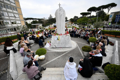 Un grupo de peregrinos rusos se reúne junto a la estatua de Juan Pablo II en la entrada del Hospital Gemelli, donde está hospitalizado el Papa Francisco, en Roma, Italia, el 11 de marzo de 2025.
