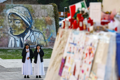 Monjas rezan cerca de la estatua de Juan Pablo II en la entrada del Hospital Gemelli, donde está hospitalizado el Papa Francisco, en Roma, Italia.