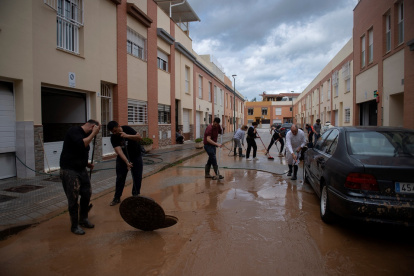 Los residentes limpian su calle inundada en Campanillas, cerca de Málaga, sur de España, el 18 de marzo de 2025.