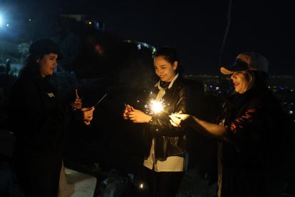 Niñas iraníes encienden petardos durante una fiesta tradicional del fuego llamada "Charshanbeh Suri" en Teherán, Irán, el 18 de marzo de 2025.