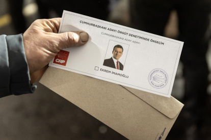 Una hombre muestra una papeleta con la efigie del alcalde de Estambul, Ekrem Imamoglu.