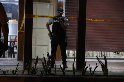 Un agente policial custodia la escena del crimen en el cangrejal de Sauces 6, la noche del miércoles 26 de marzo.